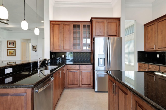 8273 Razorback Ct, Boynton Beach, FL 33473 - kitchen with stainless steel appliances, ornamental molding, a sink, dark stone counters, and brown cabinets