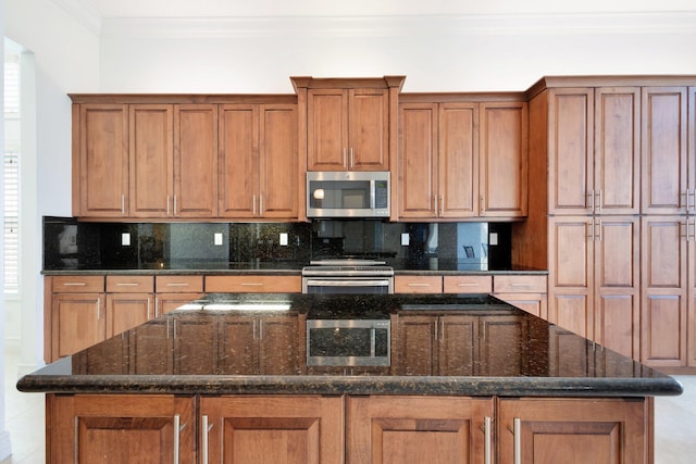 8273 Razorback Ct, Boynton Beach, FL 33473 - kitchen with stainless steel appliances, brown cabinets, decorative backsplash, a kitchen island, and ornamental molding