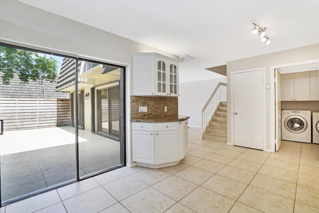 707 7th Ter, Palm Beach Gardens, FL 33418 - kitchen featuring independent washer and dryer, backsplash, glass insert cabinets, light tile patterned flooring, and white cabinetry