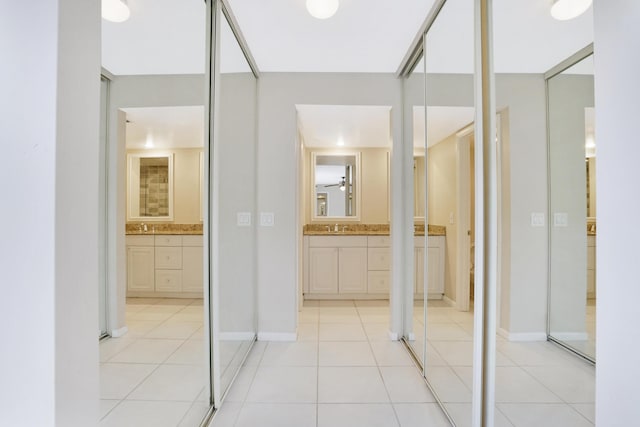 707 7th Ter, Palm Beach Gardens, FL 33418 - hallway featuring light tile patterned flooring, a sink, and baseboards