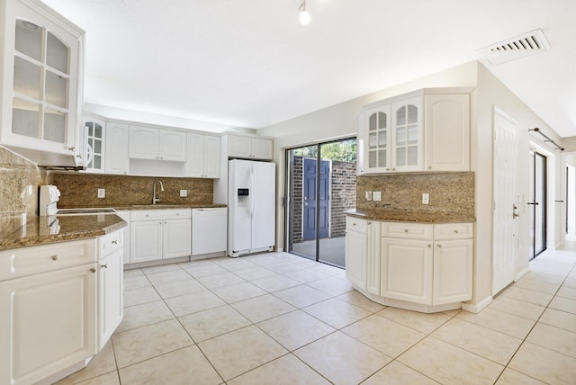 707 7th Ter, Palm Beach Gardens, FL 33418 - kitchen featuring white appliances, decorative backsplash, light tile patterned flooring, and dark stone countertops