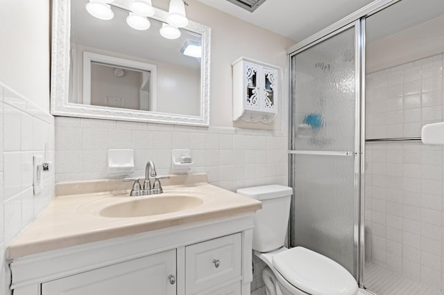 2050 NE 39th St Unit 110S, Lighthouse Point, FL 33064 - full bathroom featuring vanity, toilet, a shower stall, tile walls, and wainscoting