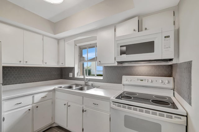 kitchen featuring white appliances, a sink, backsplash, and light countertops