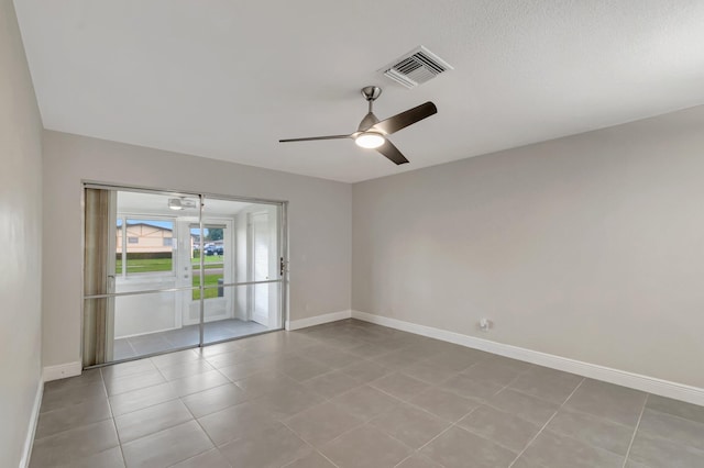 empty room with baseboards, ceiling fan, and tile patterned floors