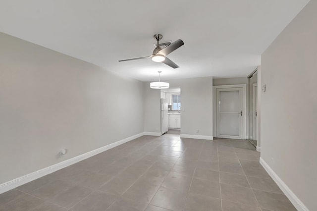 unfurnished living room with ceiling fan, light tile patterned flooring, and baseboards