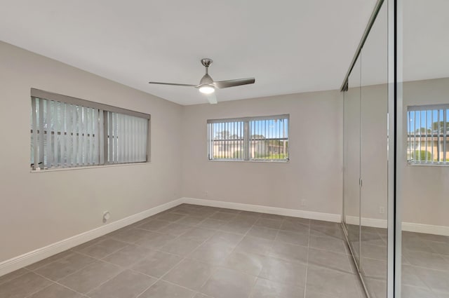 unfurnished bedroom with tile patterned floors, baseboards, a closet, and ceiling fan