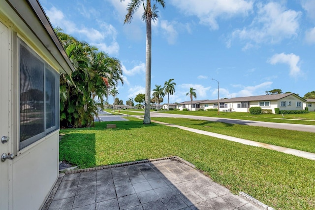 view of grassy yard with a residential view