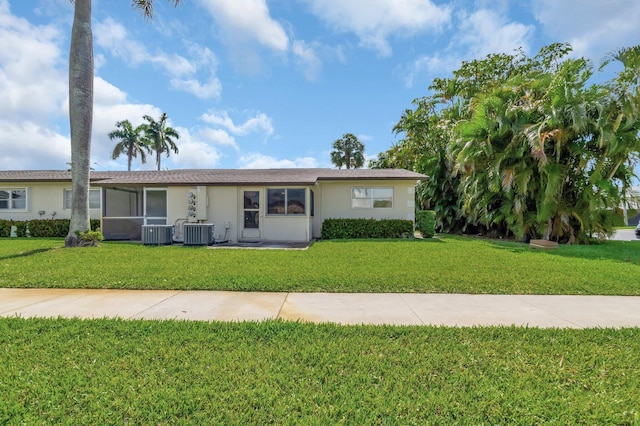 ranch-style home with a front lawn, central AC, and stucco siding