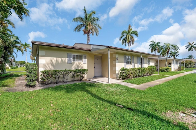 single story home featuring stucco siding and a front lawn