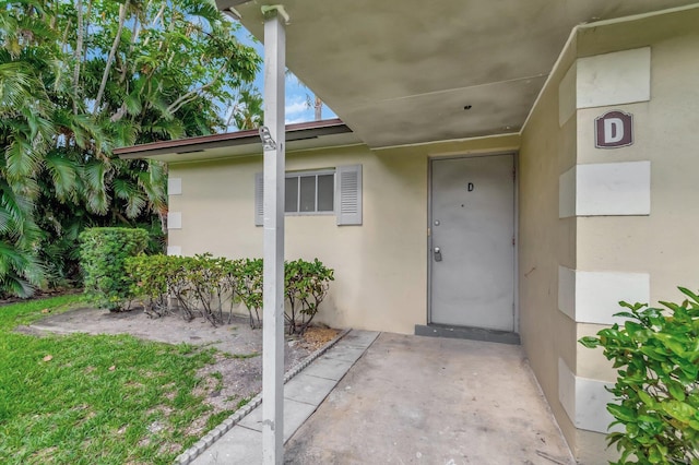 doorway to property featuring stucco siding