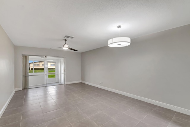 spare room featuring baseboards, ceiling fan, and light tile patterned floors