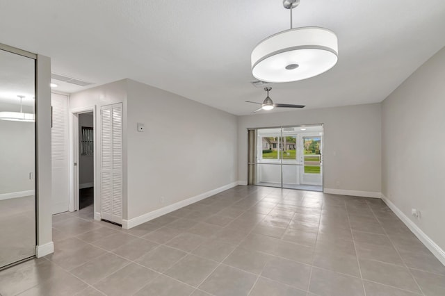 unfurnished room with a ceiling fan, light tile patterned floors, and baseboards