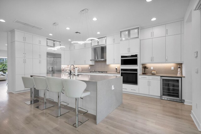 13444 Bernoulli Way, Palm Beach Gardens, FL 33418 - kitchen featuring wine cooler, stainless steel built in fridge, double oven, light wood finished floors, and recessed lighting