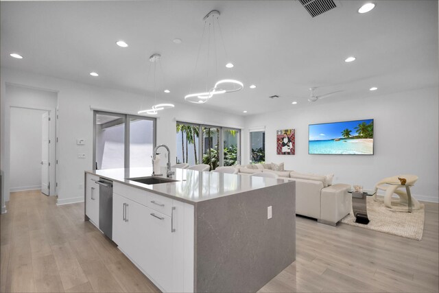 13444 Bernoulli Way, Palm Beach Gardens, FL 33418 - kitchen featuring a sink, an island with sink, recessed lighting, pendant lighting, and white cabinetry