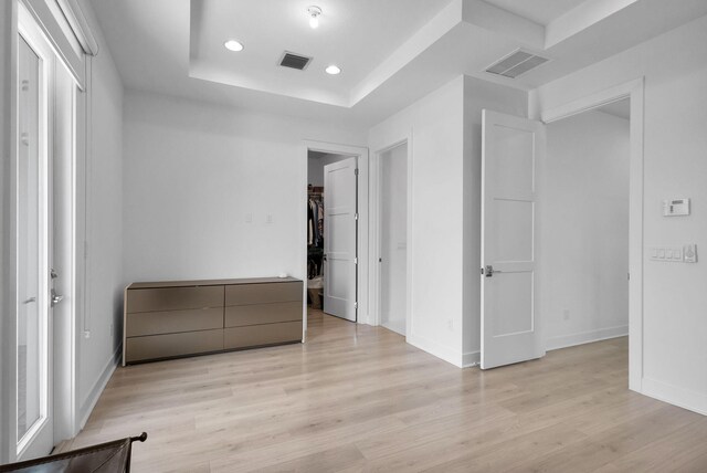 13444 Bernoulli Way, Palm Beach Gardens, FL 33418 - unfurnished bedroom featuring a raised ceiling, recessed lighting, light wood-style floors, baseboards, and a walk in closet