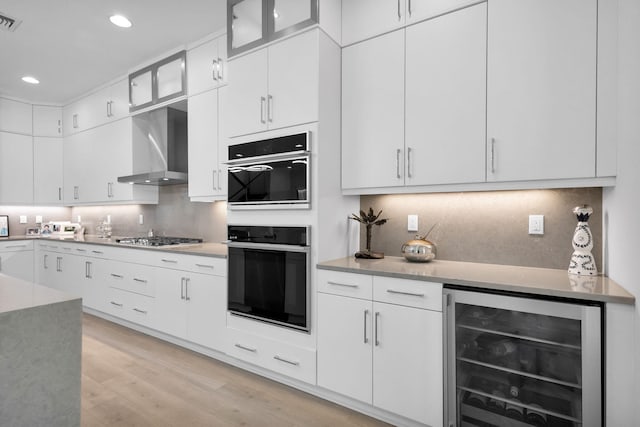 13444 Bernoulli Way, Palm Beach Gardens, FL 33418 - kitchen featuring beverage cooler, wall chimney exhaust hood, gas stovetop, light countertops, and recessed lighting