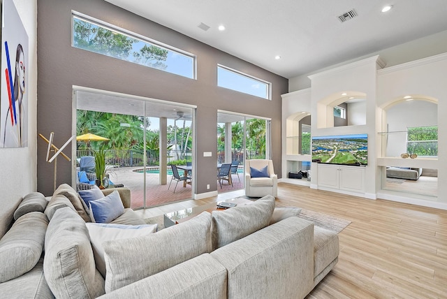 8405 Legend Club Dr, West Palm Beach, FL 33412 - living room with recessed lighting, a towering ceiling, wood finished floors, built in shelves, and baseboards