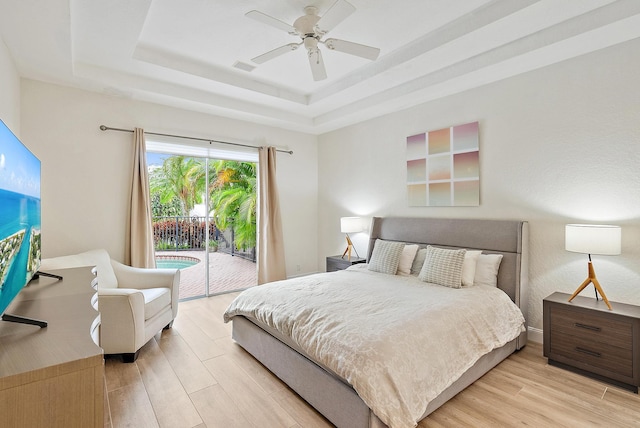 8405 Legend Club Dr, West Palm Beach, FL 33412 - bedroom with access to exterior, a tray ceiling, light wood-style floors, and ceiling fan