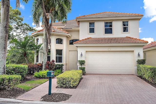8405 Legend Club Dr, West Palm Beach, FL 33412 - mediterranean / spanish house featuring decorative driveway, an attached garage, a tile roof, and stucco siding