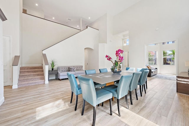 8405 Legend Club Dr, West Palm Beach, FL 33412 - dining space featuring a high ceiling, stairs, arched walkways, light wood-style floors, and recessed lighting