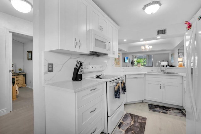 23247 Barwood Ln Unit 305, Boca Raton, FL 33428 - kitchen with white appliances, a sink, white cabinetry, a chandelier, and light wood-style floors