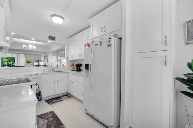 23247 Barwood Ln Unit 305, Boca Raton, FL 33428 - kitchen with white fridge with ice dispenser, white cabinetry, a sink, a chandelier, and recessed lighting