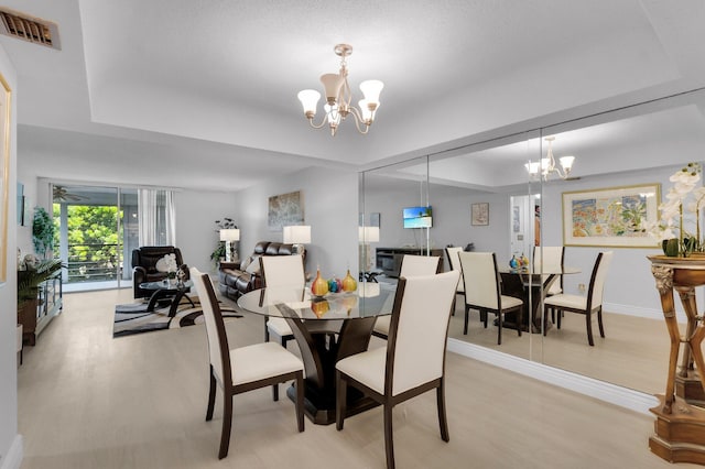 23247 Barwood Ln Unit 305, Boca Raton, FL 33428 - dining area with a chandelier, a tray ceiling, and light wood-type flooring