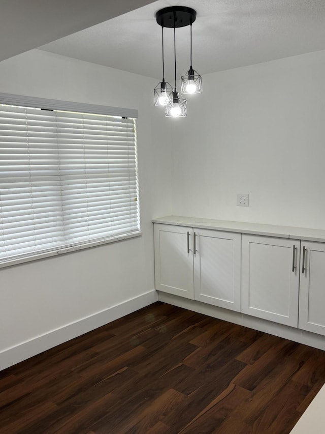 7690 Tahiti Ln Unit 102, Lake Worth, FL 33467 - unfurnished dining area with dark wood-style floors and baseboards
