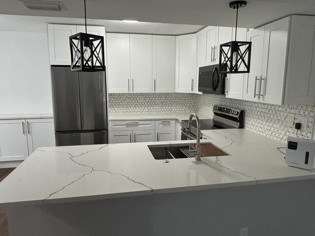 7690 Tahiti Ln Unit 102, Lake Worth, FL 33467 - kitchen with appliances with stainless steel finishes, tasteful backsplash, light stone countertops, and white cabinets