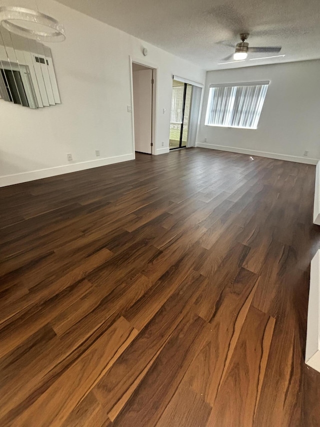 7690 Tahiti Ln Unit 102, Lake Worth, FL 33467 - empty room featuring dark wood-style flooring, baseboards, ceiling fan, and a textured ceiling