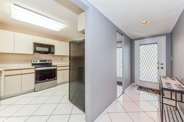 15324 Lakes Of Delray Blvd Unit 210, Delray Beach, FL 33484 - kitchen featuring black appliances, a textured ceiling, light tile patterned flooring, and light countertops