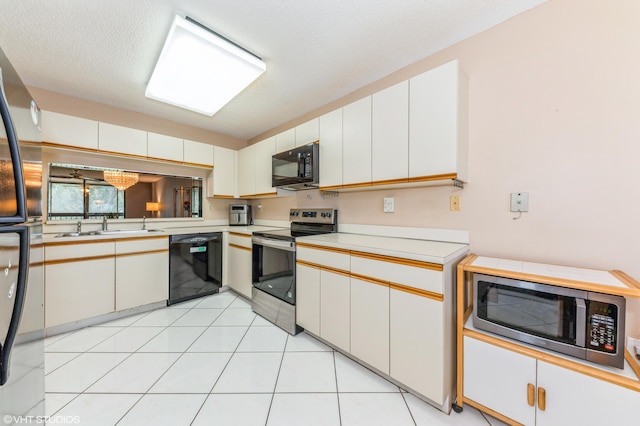 15324 Lakes Of Delray Blvd Unit 210, Delray Beach, FL 33484 - kitchen featuring black appliances, light countertops, and white cabinets