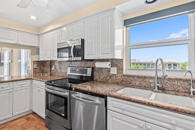 1040 Banyan Rd Unit 501C, Boca Raton, FL 33432 - kitchen with stainless steel appliances, a sink, white cabinets, backsplash, and light tile patterned floors