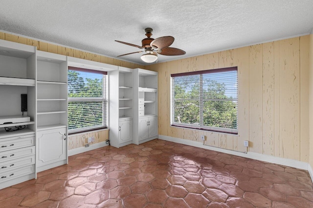 1040 Banyan Rd Unit 501C, Boca Raton, FL 33432 - unfurnished bedroom featuring wood walls, baseboards, a textured ceiling, and ceiling fan