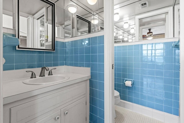 1040 Banyan Rd Unit 501C, Boca Raton, FL 33432 - bathroom featuring tile walls, vanity, toilet, and tile patterned flooring