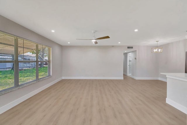 spare room with light wood-style flooring, a chandelier, baseboards, recessed lighting, and ceiling fan
