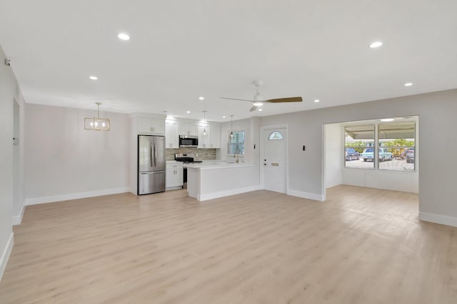 unfurnished living room featuring baseboards, light wood-style flooring, recessed lighting, a sink, and a ceiling fan