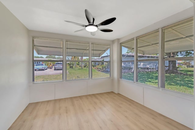 unfurnished sunroom featuring wood finished floors and plenty of natural light