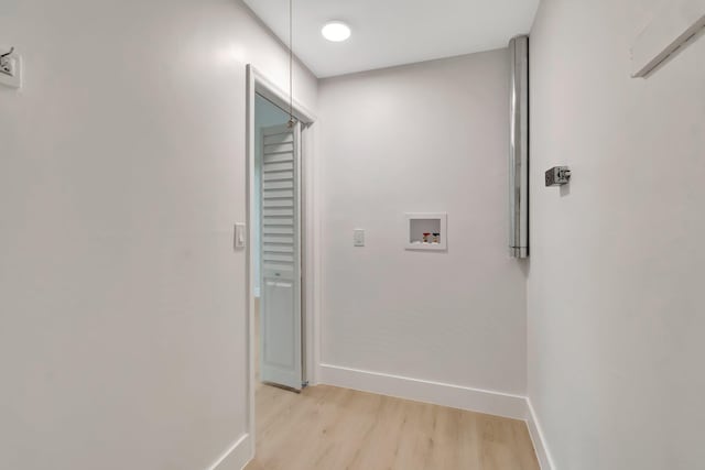 corridor featuring light wood-style flooring and baseboards