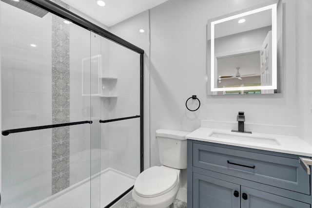 bathroom featuring toilet, a stall shower, vanity, a ceiling fan, and recessed lighting