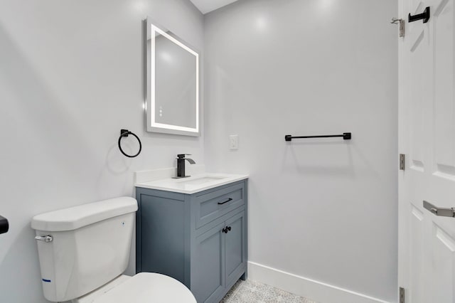 bathroom with toilet, baseboards, and vanity