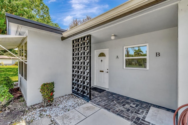 entrance to property featuring stucco siding