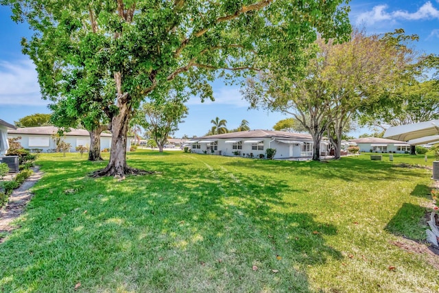 470 High Point Dr Unit A, Delray Beach, FL 33445 - view of grassy yard featuring central AC unit