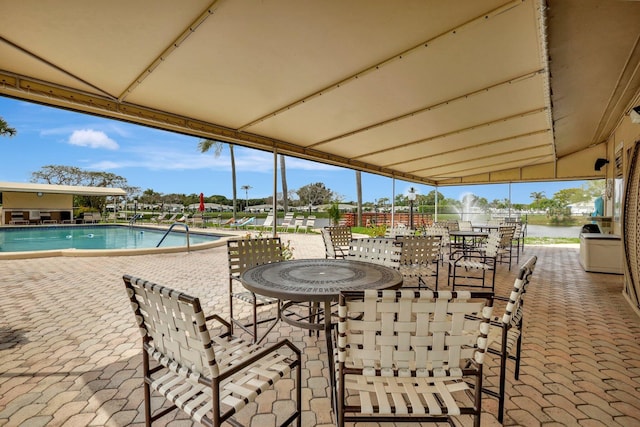 view of patio / terrace featuring a community pool and a water view