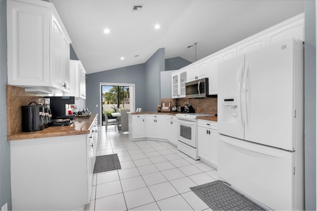 10393 Lexington Cir S, Boynton Beach, FL 33436 - kitchen with white appliances, backsplash, light tile patterned flooring, white cabinetry, and lofted ceiling