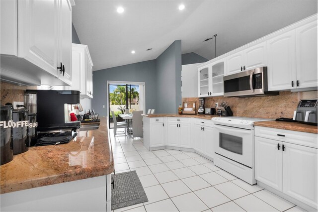 10393 Lexington Cir S, Boynton Beach, FL 33436 - kitchen featuring stainless steel microwave, electric stove, backsplash, vaulted ceiling, and light tile patterned floors