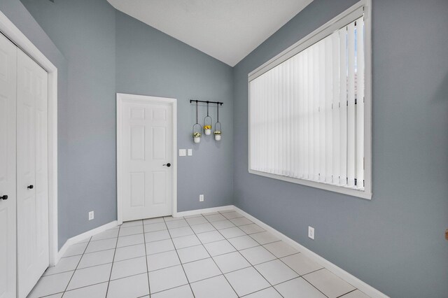 10393 Lexington Cir S, Boynton Beach, FL 33436 - unfurnished room with lofted ceiling, baseboards, and light tile patterned floors
