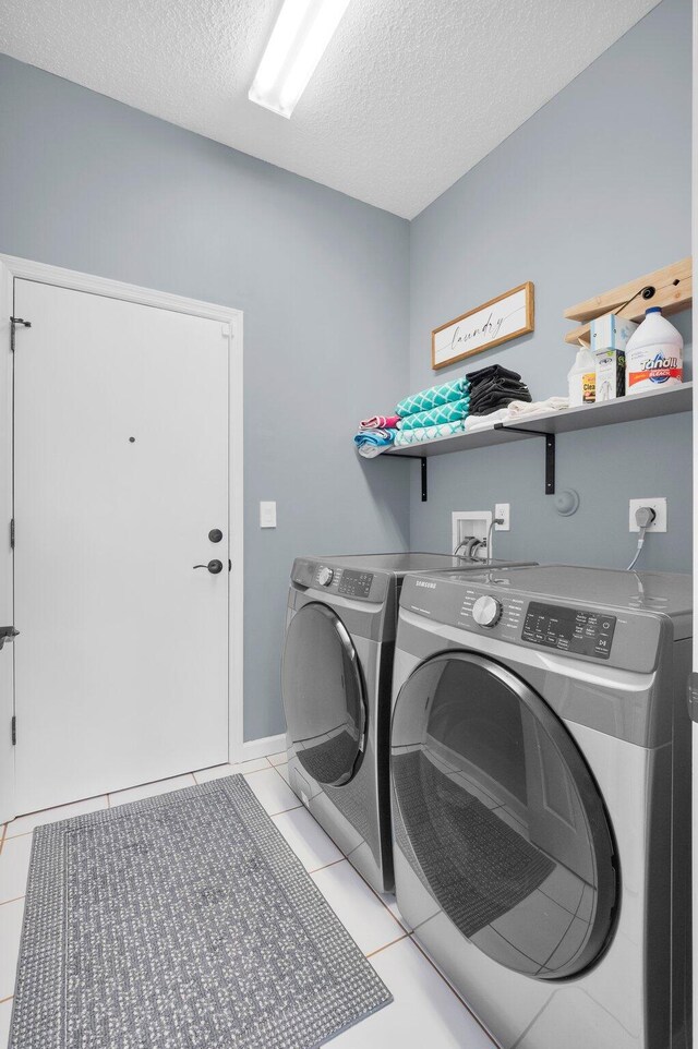 10393 Lexington Cir S, Boynton Beach, FL 33436 - washroom featuring washing machine and dryer, a textured ceiling, and light tile patterned floors
