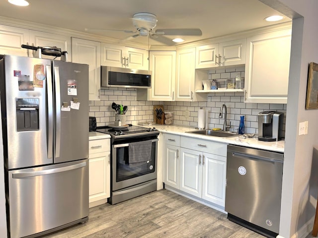 215 Monaco E, Delray Beach, FL 33446 - kitchen featuring stainless steel appliances, a sink, ceiling fan, white cabinetry, and backsplash