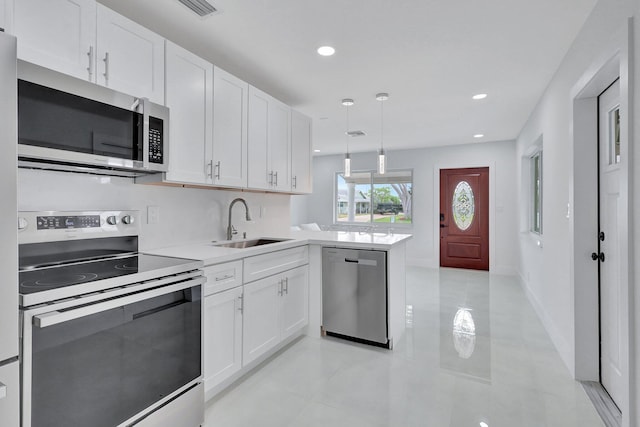 5305 Cleveland Rd, Delray Beach, FL 33484 - kitchen with appliances with stainless steel finishes, a sink, a peninsula, white cabinets, and light countertops